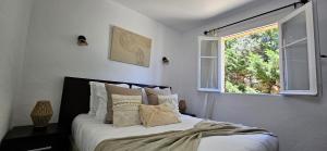 une chambre avec un lit avec des oreillers et une fenêtre dans l'établissement T2 Résidence Dolce & Vita C5 vue mer et piscine, à Propriano