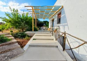 a staircase leading to a house with a pergola at Casina La Tajata in Manduria +22 photos