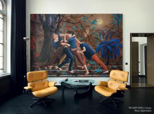 a painting on the wall in a room with chairs at THE QVEST hideaway in Cologne
