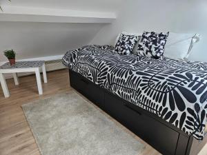 a black and white bed in a room with a table at spacieux duplex Stade de France 24 pour 4 personnes in Saint-Denis