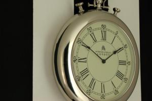 a silver pocket watch hanging on a wall at Home BB Milano in Milan