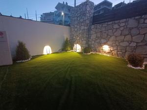 a large yard with a stone building with lights at ALTA MARE in Nea Peramos