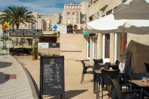 una cafetería al aire libre con mesas, sillas y sombrillas en El Rinconet de Loreto, en El Campello