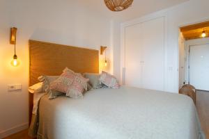 Un dormitorio con una cama grande con almohadas. en El Rinconet de Loreto, en El Campello