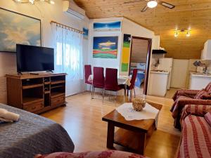 a living room with a television and a table with chairs at Apartments Alex in Rovinj