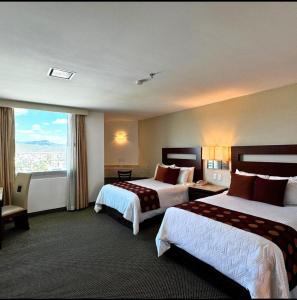 a hotel room with two beds and a large window at Hotel Ankara "Las Lomas" in San Luis Potosí