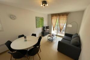 a living room with a table and a couch at Les Naïades C14 - 2 bedrooms for 6 people ! in Avène