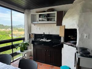 a kitchen with a sink and a large window at Bombinhas in Bombinhas