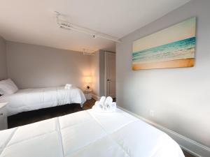 a bedroom with two beds and a painting on the wall at Water Access 5-Bed 2-Bath Retreat in Barnstable