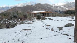 a house in the snow with mountains in the background at Barranca de la Luna in Tafí del Valle +3 photos