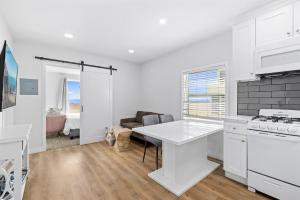 a white kitchen with a table and a couch at 1628 West Oceanfront Oasis 8 in Newport Beach +18 photos