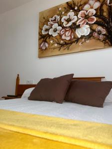 a bedroom with a bed with a painting on the wall at A Casa de Santos in Combarro
