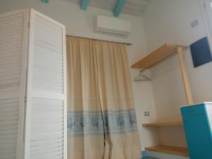 アルゲーロにあるPiccolo paradisoのカーテンのかかった部屋の半開きのドア