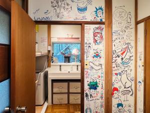 una cucina con un muro e disegni di XXUFO ad Atami