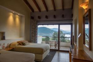 1 dormitorio con 2 camas y balcón con vistas. en Hotel Villas Paraiso, en Valle de Bravo