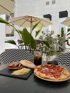 a table with two plates of pizza and a drink at La Boutique Puerta Osario in Córdoba +35 photos