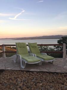 two lounge chairs sitting on a patio near the water at House Bepo in Nerežišće +13 photos
