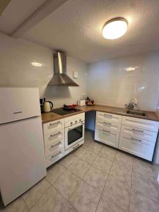 a kitchen with white cabinets and a white refrigerator at House Bepo in Nerežišće