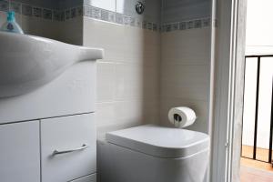 a white bathroom with a toilet and a sink at Ca' Da Marghe - San Terenzo in San Terenzo