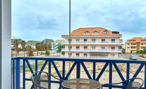 a balcony with a table and chairs and a building at Casa Branca Beach in Santa Maria