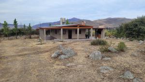a small house in the middle of a field at Barranca de la Luna in Tafí del Valle +5 photos