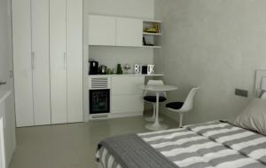 a bedroom with a bed and a table and a kitchen at Home BB Milano in Milan