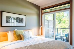 a bedroom with a bed and a large window at Lakefront, Mountain View - 2 Bedrooms Resort Suite in Lac-Superieur