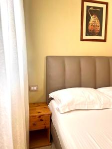 a bedroom with a bed and a wooden nightstand next to a bed sidx sidx at Chalet Ambel in Dhërmi