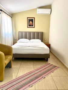 a bedroom with a bed and a couch at Chalet Ambel in Dhërmi