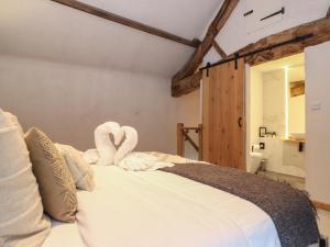a bedroom with a bed with towels on it at Meadow Syke Byre in Penrith