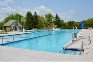 a large swimming pool with a house in the background at Perfect Vacation Home with Game Room Theater Hot Tub in Tobyhanna