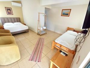a room with a bed and a chair and a couch at Chalet Ambel in Dhërmi