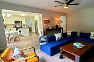 a living room with a blue couch and a table at Perfect Vacation Home with Game Room Theater Hot Tub in Tobyhanna