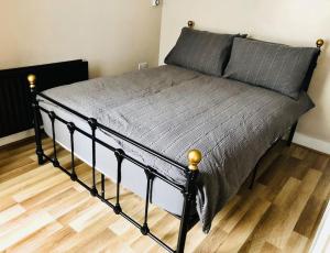 a bed in a bedroom with a wooden floor at Cliftonville Apartments in Belfast