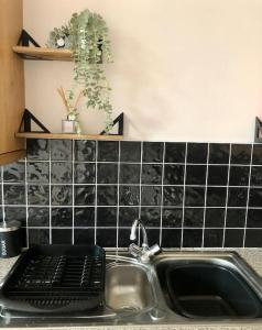 a kitchen sink with a black tile backsplash at Cliftonville Apartments in Belfast
