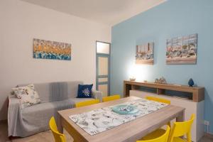 a living room with a table and yellow chairs at Home holiday Kalanto in Castellammare del Golfo