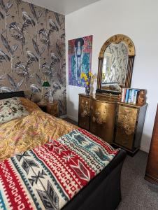 ヘルムズデールにあるSelkie House Song of the Seaのベッドとドレッサーと鏡のある寝室