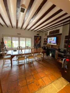 a dining room with a table and chairs and a tv at Bungalow GOLOSINA in Torrelaguna