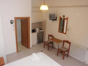 a room with a kitchen and a table and chairs at Vazakas Rooms in Mytilene