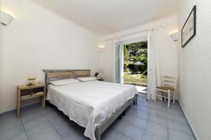 a white bedroom with a bed and a window at Casa Margherita Ischia in Ischia