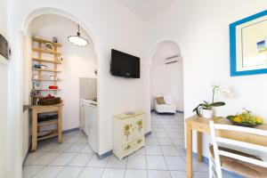 a living room with a table and a tv on a wall at Casa Margherita Ischia in Ischia