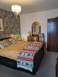 ヘルムズデールにあるSelkie House Song of the Seaのベッドとドレッサーと鏡のある寝室