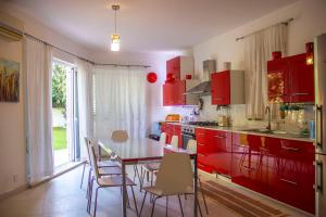 a kitchen with red cabinets and a table with chairs at Villa Balluta in St Julian's