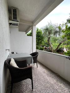 a patio with a table and chairs on a balcony at Rooms Kate in Krk