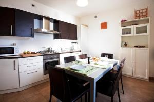 a kitchen with a table and chairs and a kitchen with a stove at Residenza Romina sleeps 8 with pool- by Italian Apartments in Rezzonico +9 photos
