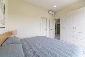 普拉亚卡门Penthouse with Jungle View Terrace Gym Pool HotTub的一间带床和白色橱柜的白色卧室 更多27张照片