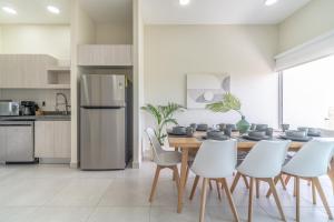 普拉亚卡门Penthouse with Jungle View Terrace Gym Pool HotTub的厨房兼餐厅，配有桌椅