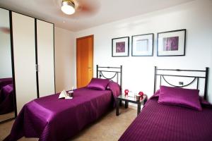 two beds in a room with purple sheets at Residenza Romina sleeps 8 with pool- by Italian Apartments in Rezzonico