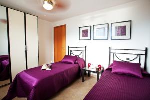 RezzonicoにあるResidenza Romina Apartmentの紫のシーツが備わる客室内のベッド2台