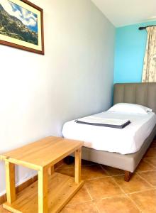 a small bedroom with a bed and a wooden table at Chalet Ambel in Dhërmi